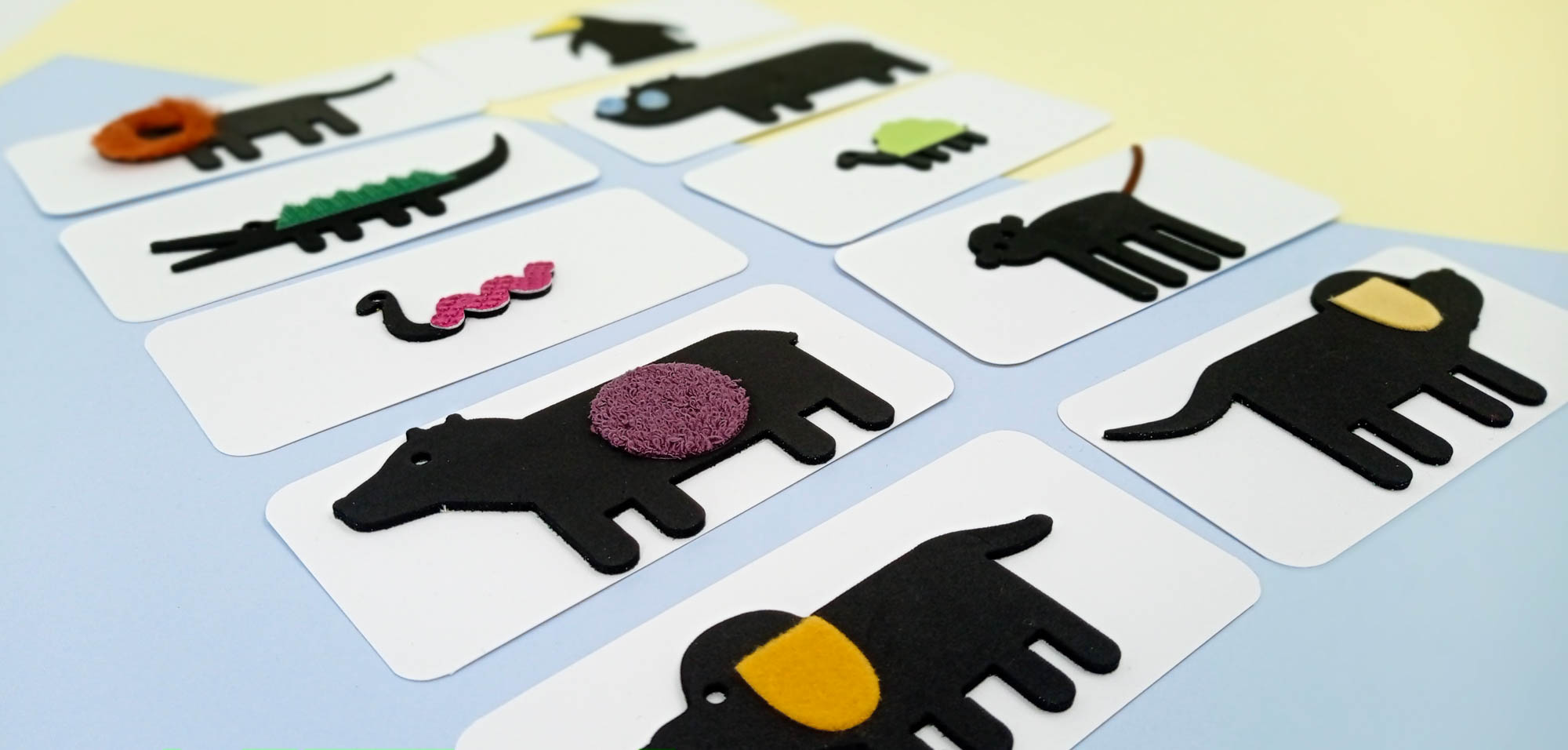 10 cartes avec au recto les 10 animaux en silhouette de profil en mousse noire épaisse et chacun un attribut tactile différent