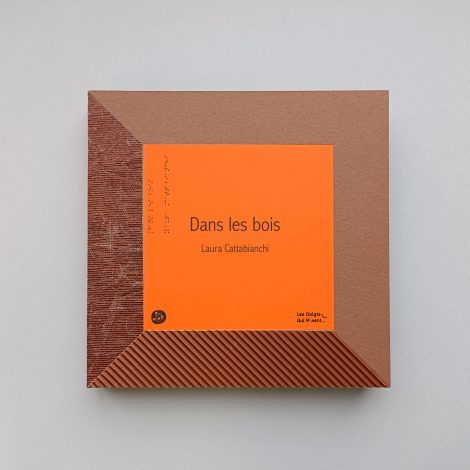 couverture orange de "dans les bois" les bords sont en cartons et papiers utilisé dans le livre