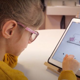 une petite fille lit un livre numérique sur une tablette