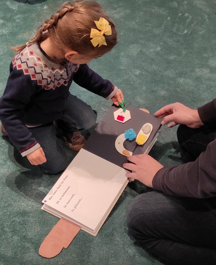 un homme et une fille lisent le livre fragile lors de l'exposition