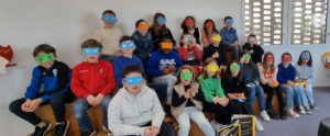 Une classe d'enfants avec des lunettes multicolores sur les yeux