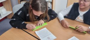 Une fillette écris en braille à l'aide d'une tablette et d'un poinçon