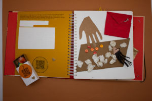 Livre tactile ouvert sur une illustration et un texte en braille avec la boîte à objet associée
