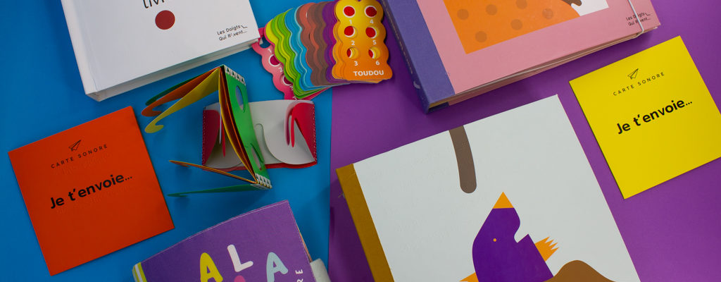Photos de couverture des livres : un livre, Mala Explore, Dans la maiason de Lala, De la petite taupe qui voulait savoir qui lui avait fait sur la tête, je t'envoie, les lunettes de simulation et le jeu des 7 familles en braille, sur un fond bleu et violet