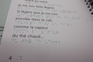Texte écrit en grand caractère et en braille du livre bon voyage petite goutte : Grâce au soleil, je me suis faite légère. Si légère que je me suis envolée dans le ciel, comme la vapeur du thé chaud.