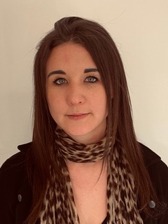 Photo de Gaëlle Mounier, cheveux bruns, longs, détaché. Elle porte une veste noir avec un foulard léopard autour du cou.