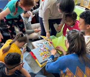 Les enfants tout autour du livre tactiles regardent les pages avec curiosité