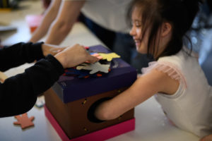 Une jeune fille decouvre le jeu tactile le carnaval des oursons destine aux enfants en situation de handicap