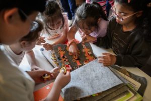 Les enfants sont tous autour d'une page, celle des bonhommes