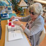 un membre du jury adulte tactus france 2026 découvre tactilement une maquette