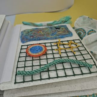 photo d'une illustration tactile du livre avec des filets de pêche dans leur différentes états de transformation pour devenir des ghosnets (corde tressée, corde détressée, ...)